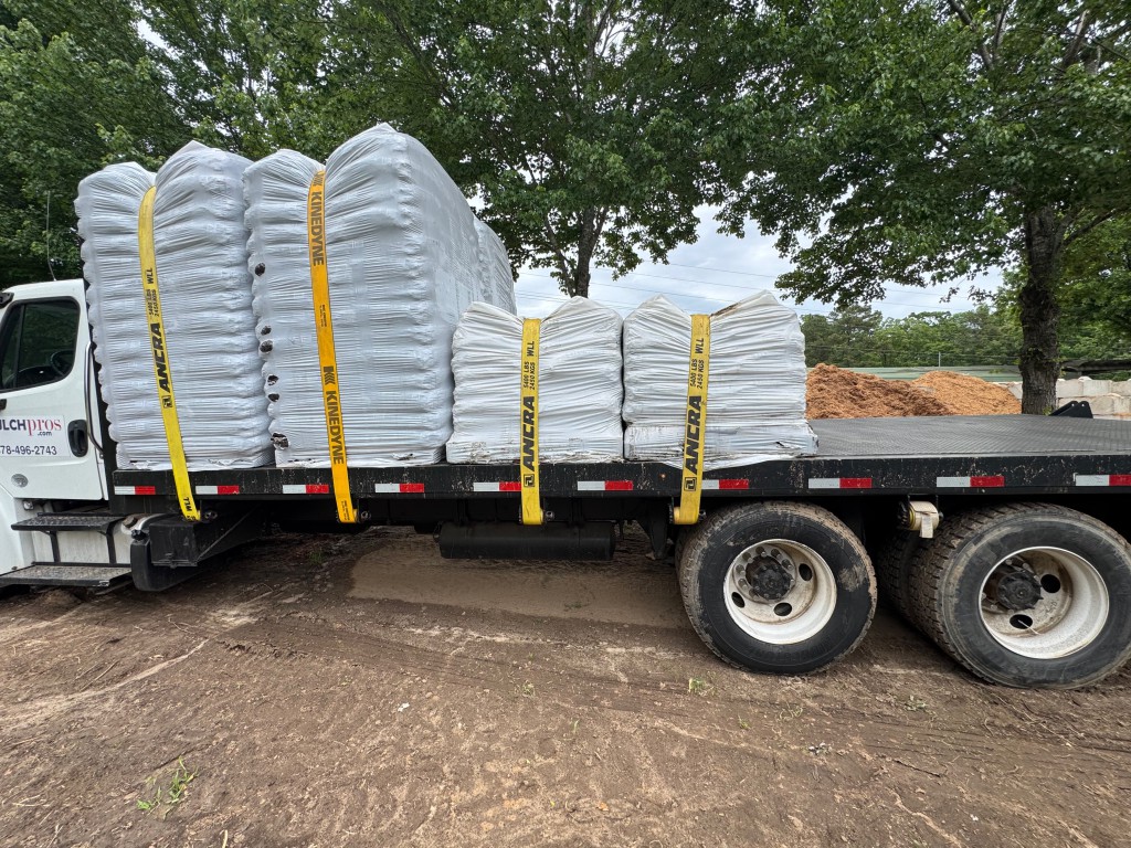 The MulchPros flatbed strapped with wrapped FIBC bulk bags for delivery.