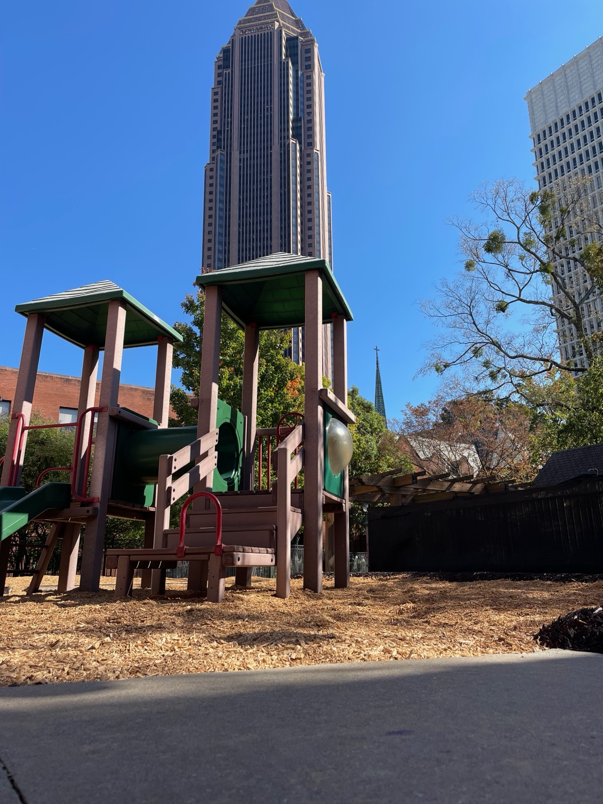 Playground towers on fresh wood fiber with an Atlanta skyscraper behind.